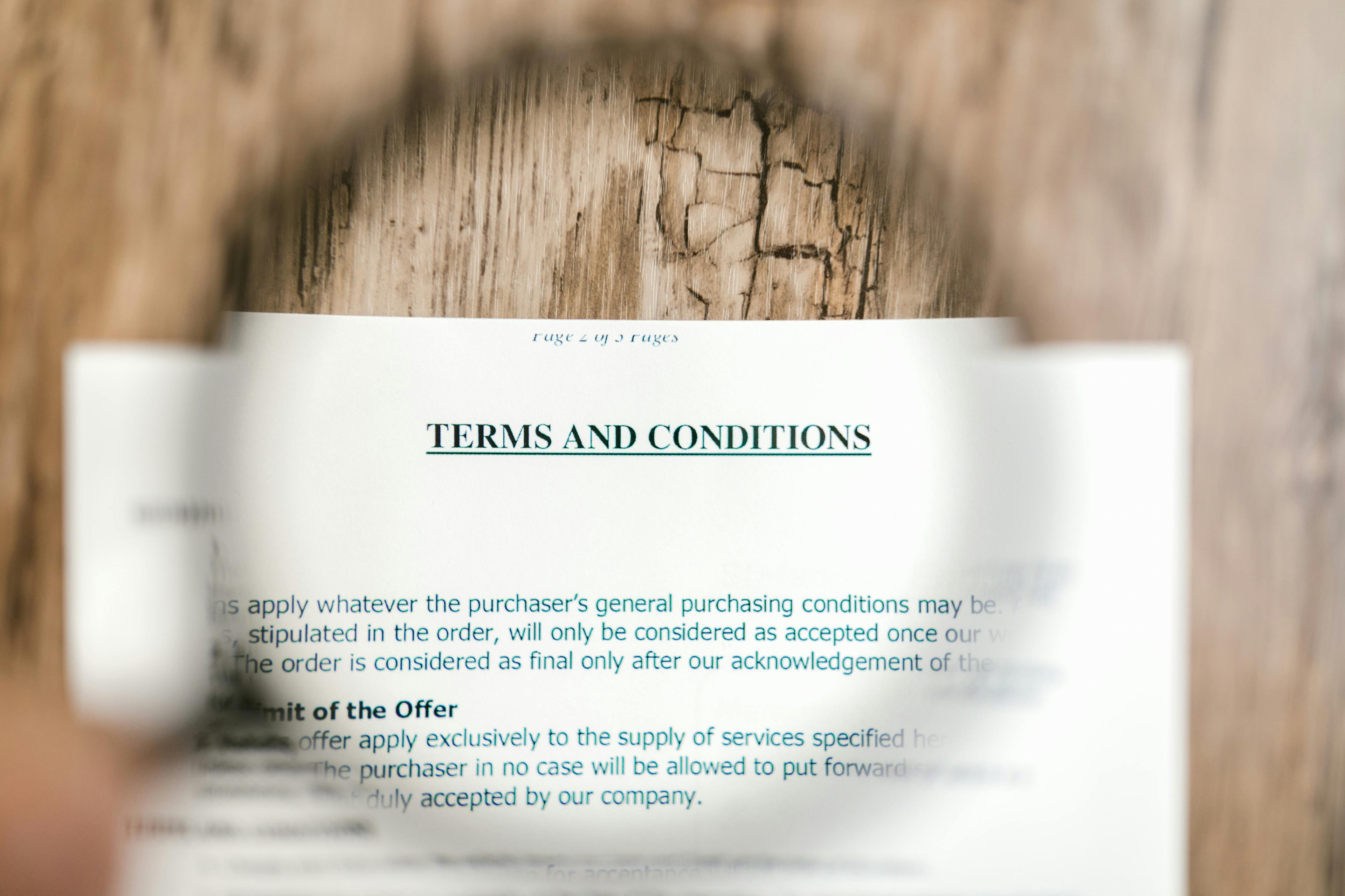 Close-up of a document with 'TERMS AND CONDITIONS' text on a wooden background